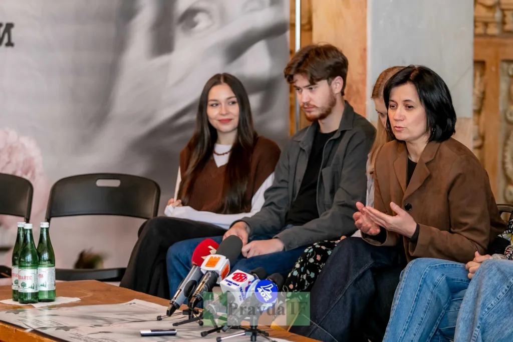 Люди на пресконференції говорять перед мікрофонами