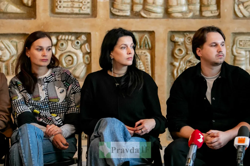 Люди на пресконференції сидять перед мікрофонами