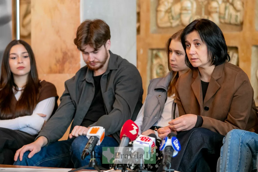 Пресконференція з кількома людьми за столом