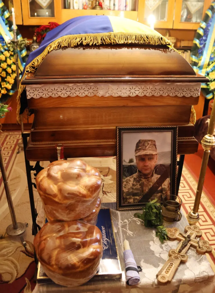 Похорон воїна з українським прапором та фотографією