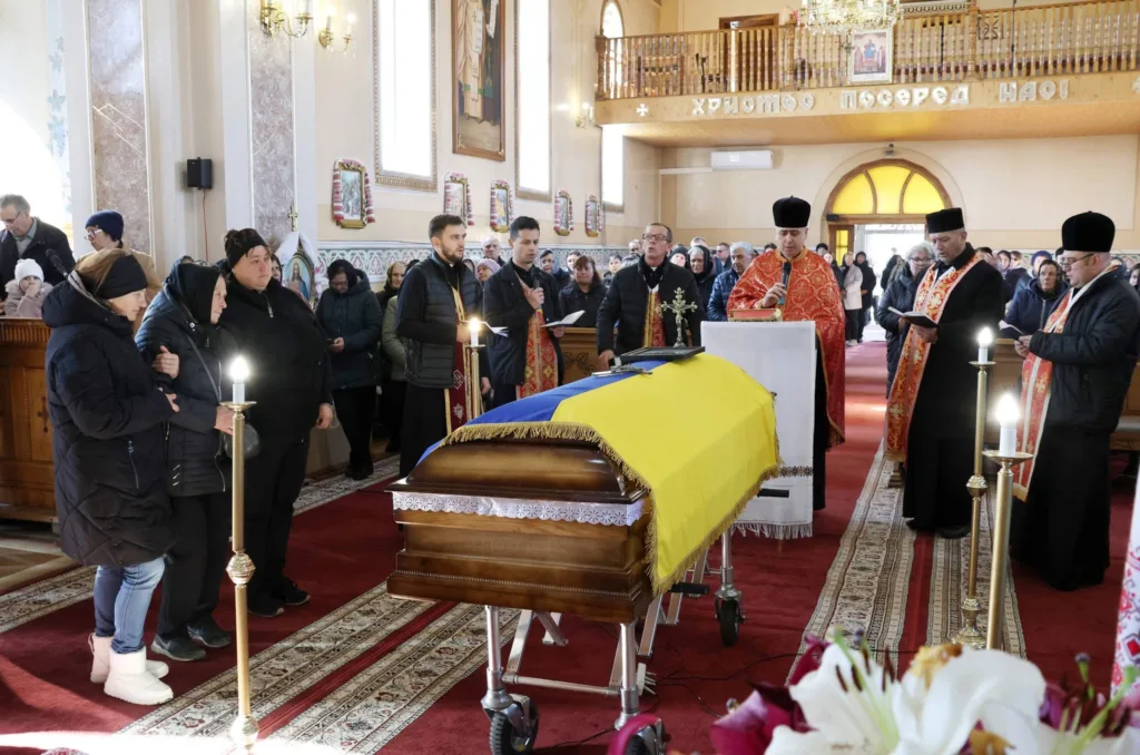 Похоронна церемонія в церкві з труною під прапором