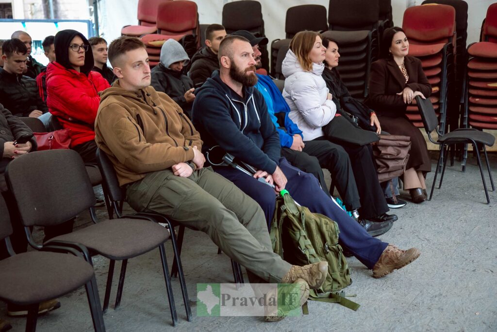Люди сидять на стільцях у залі