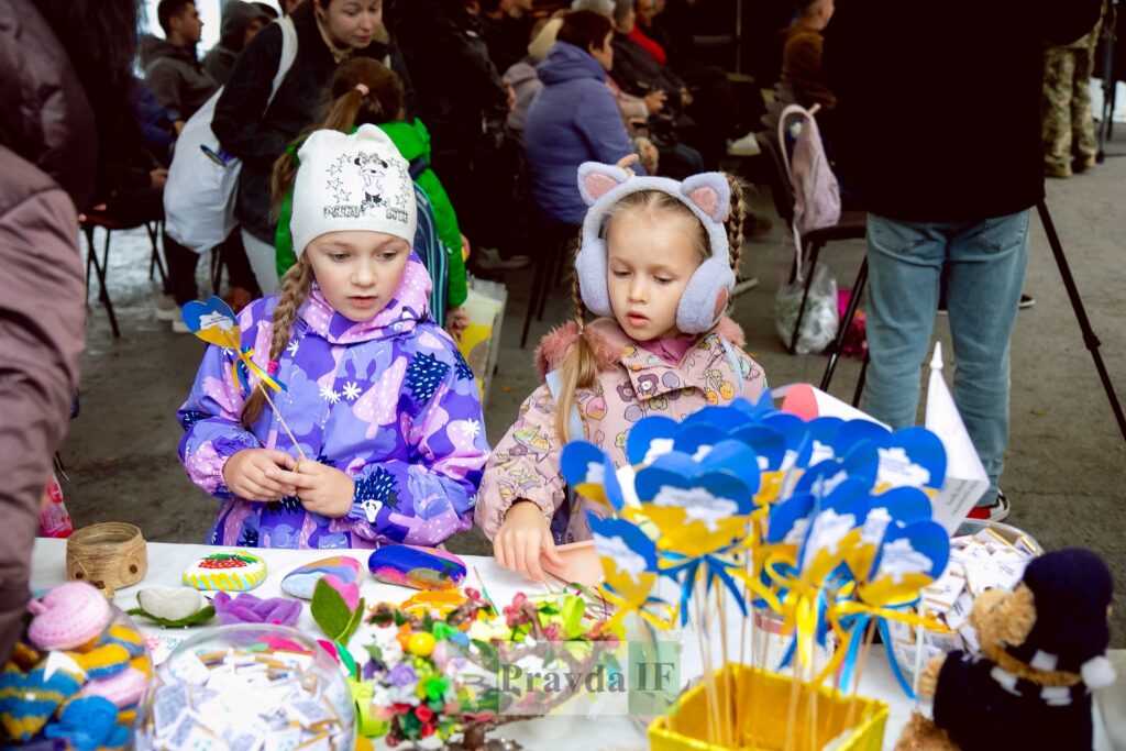 Діти розглядають сувеніри на ярмарку в Україні.