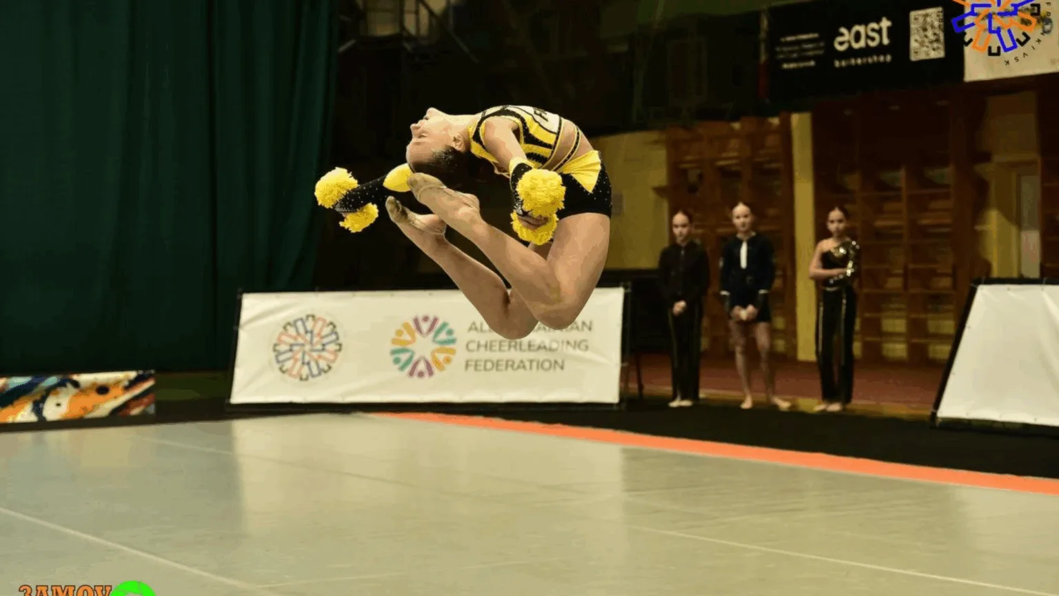 Черлідерка виконує стрибок на змаганнях