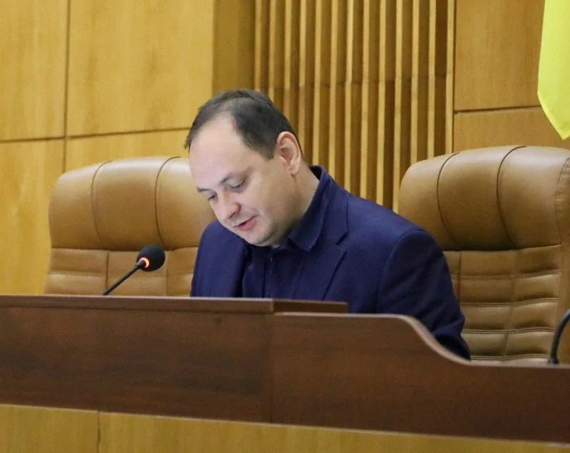 Чоловік говорить на засіданні в залі ради