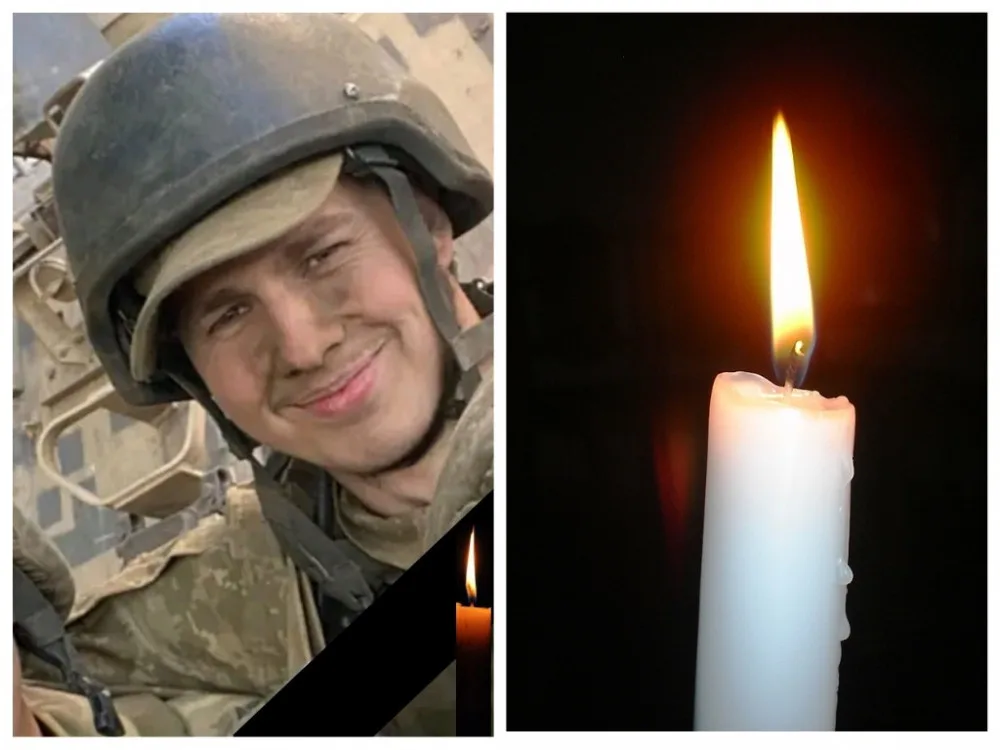 Військовий у касці поруч із запаленою свічкою.