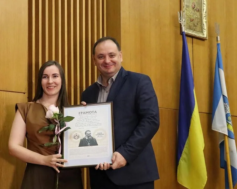 Вручення грамоти жінці з квіткою в руках