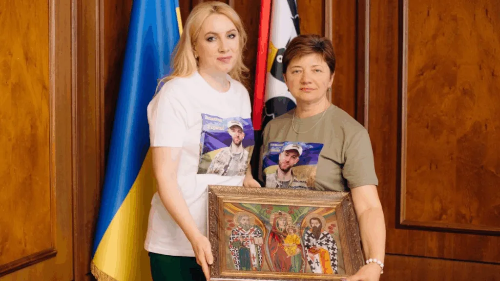 Жінки тримають ікону біля українського прапора