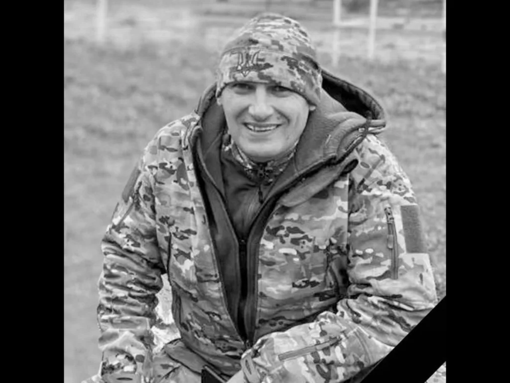 Військовий у камуфляжі сидить на вулиці