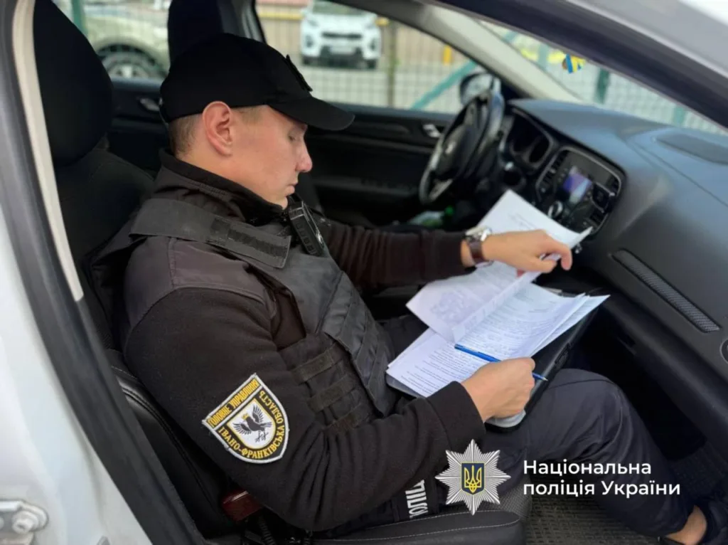 Поліцейський заповнює документи в службовому автомобілі