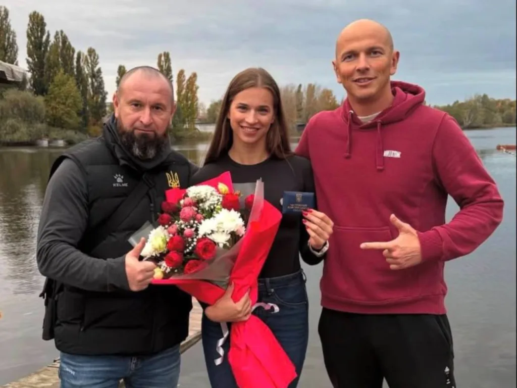 Троє людей біля річки з букетом квітів