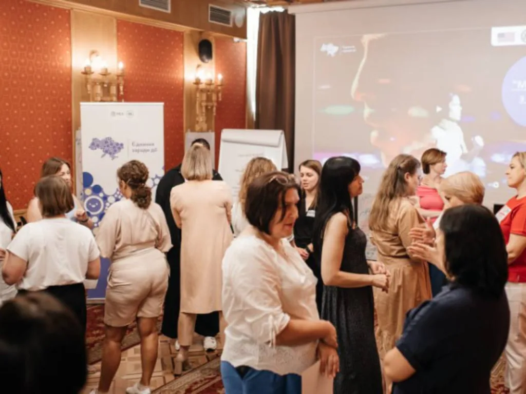 Група людей спілкується під час тренінгу у залі