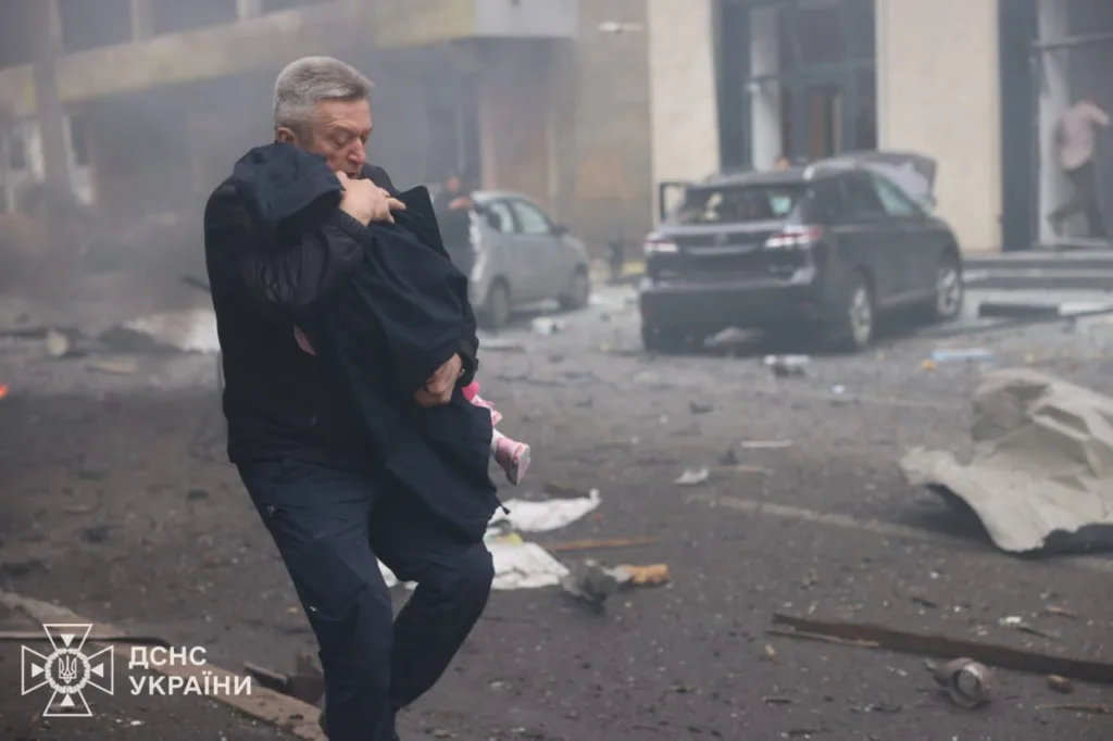 Рятувальник несе дитину після вибуху в місті