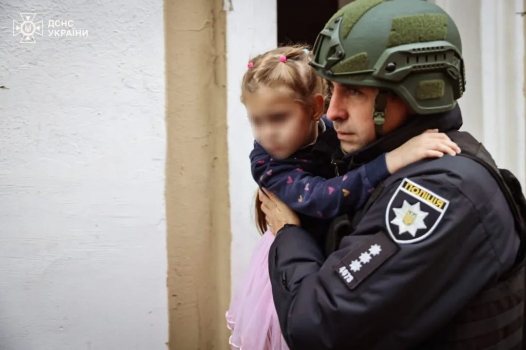 Поліцейський рятує дитину під час евакуації