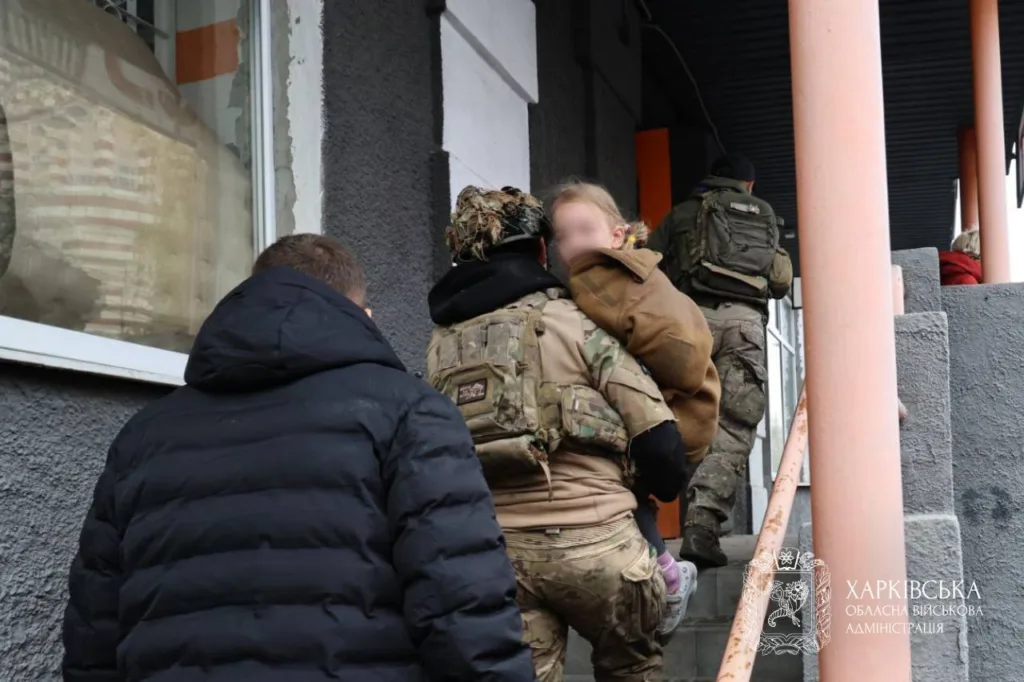 Військові несуть дитину сходами до будівлі