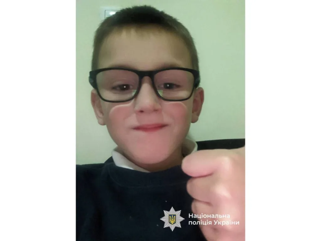 Хлопчик у окулярах усміхається на камеру