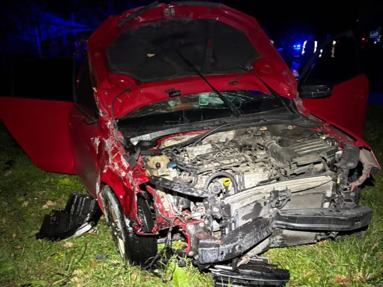 Червоне авто після дорожньо-транспортної пригоди вночі