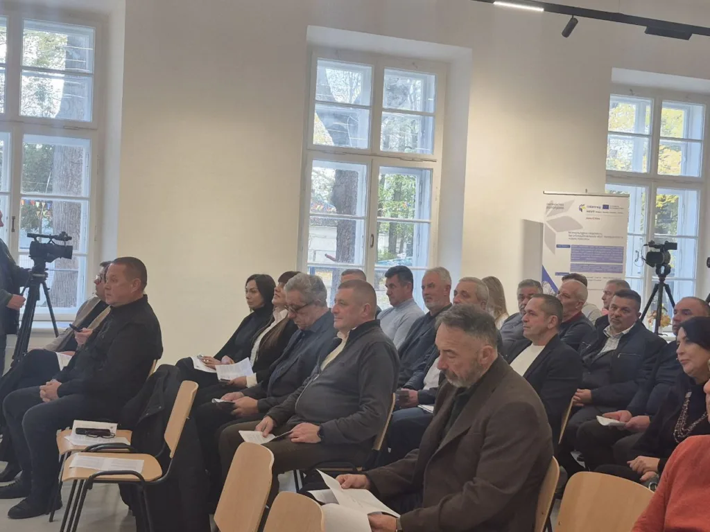 Люди сидять на конференції у світлій кімнаті