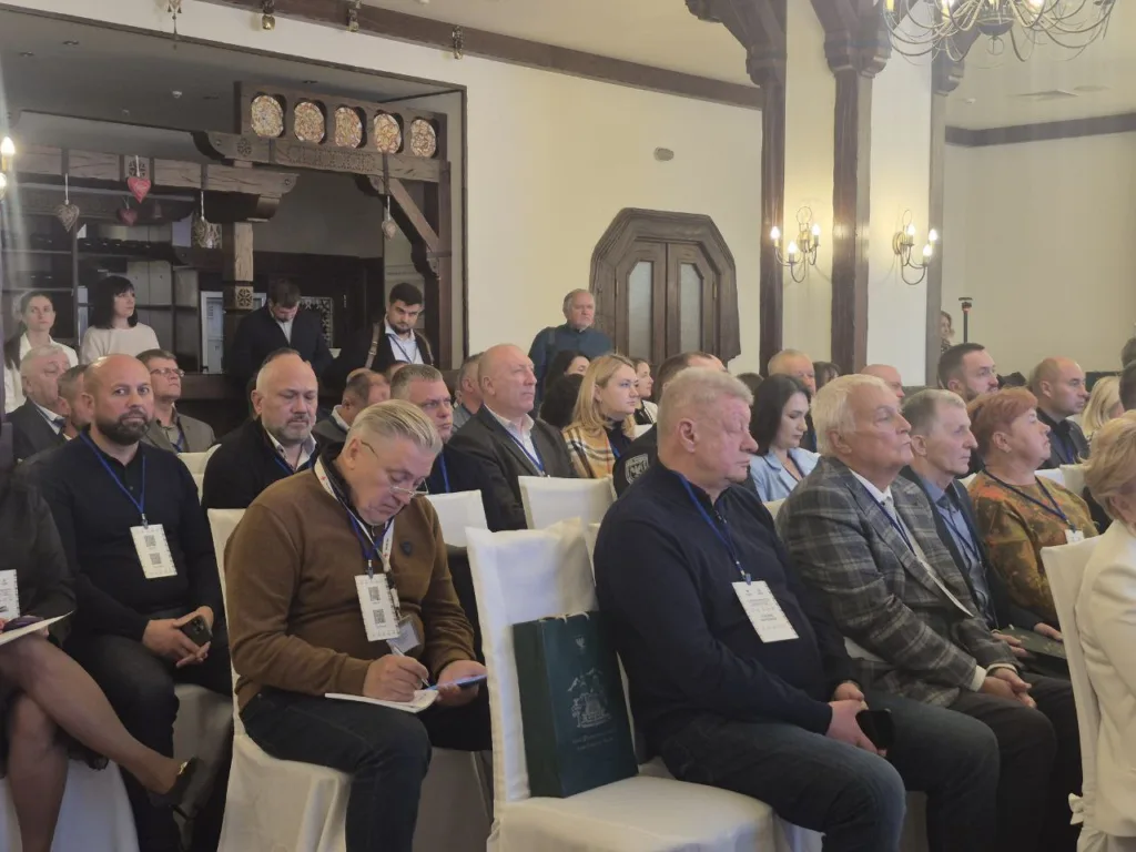 Люди сидять на конференції в залі.