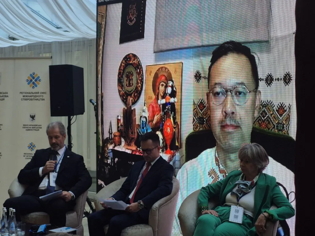 Відеоконференція: учасники на сцені та екран.