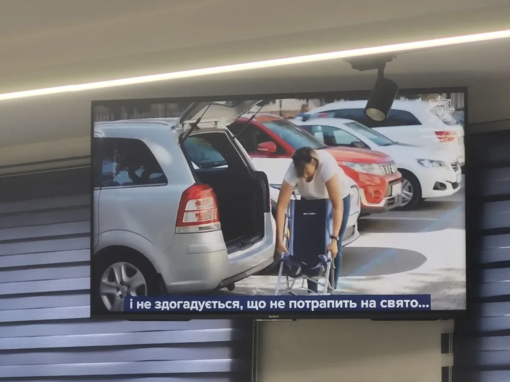 Жінка дістає інвалідний візок з автомобіля