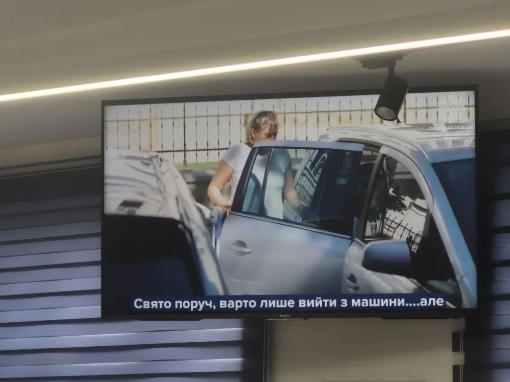 Жінка виходить з автомобіля на парковці