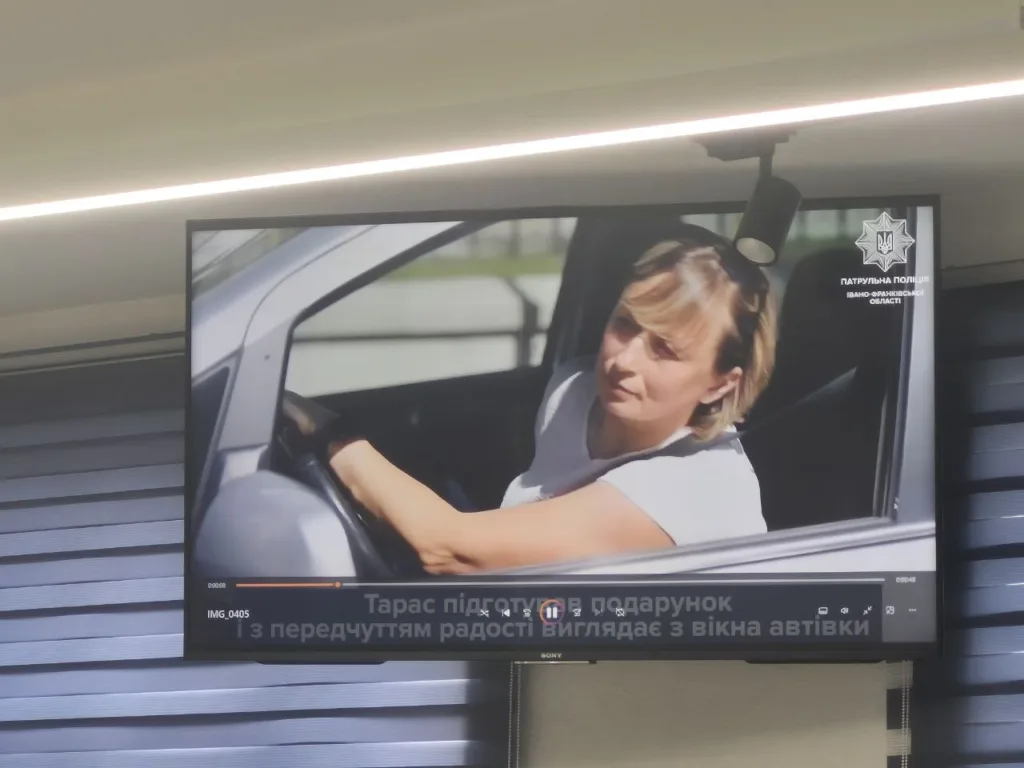 Жінка за кермом автомобіля дивиться у вікно