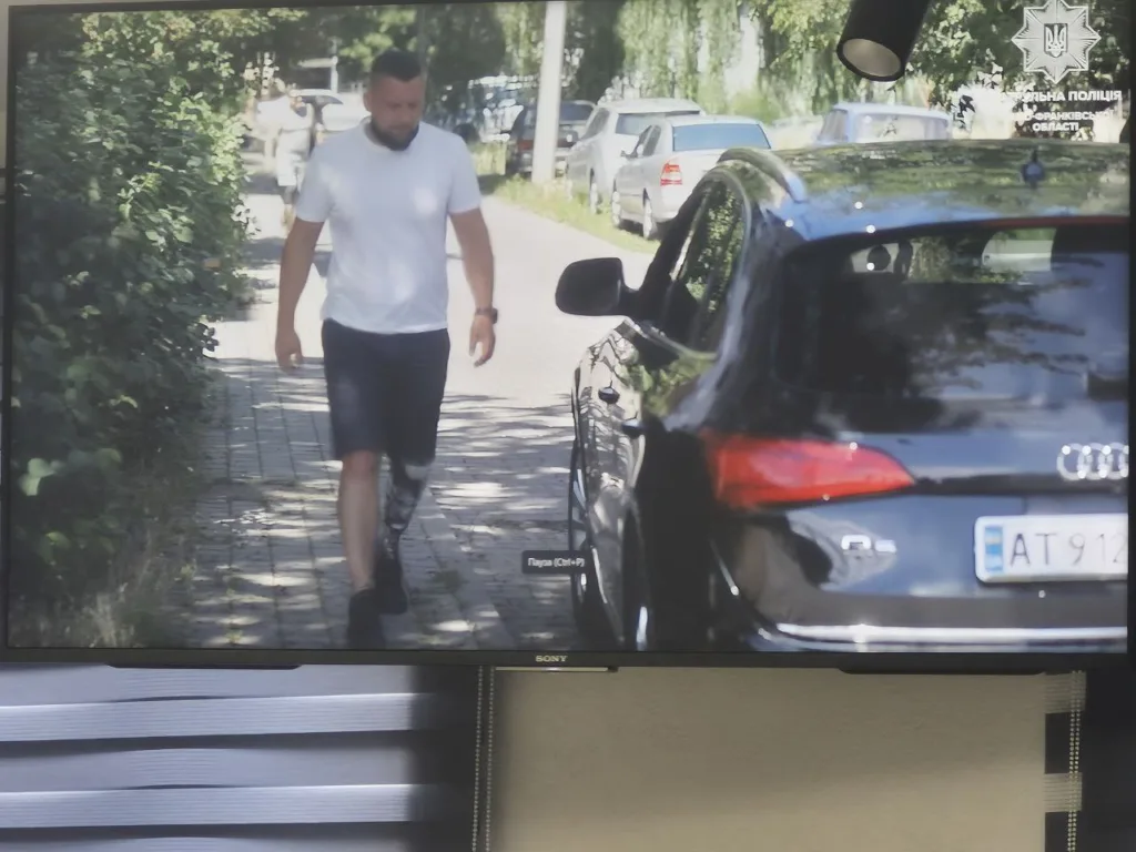 Чоловік іде поруч з автомобілем Audi на вулиці