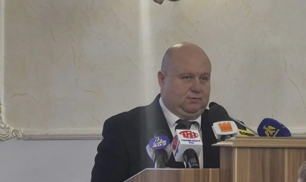 Чоловік виступає на пресконференції за трибуною