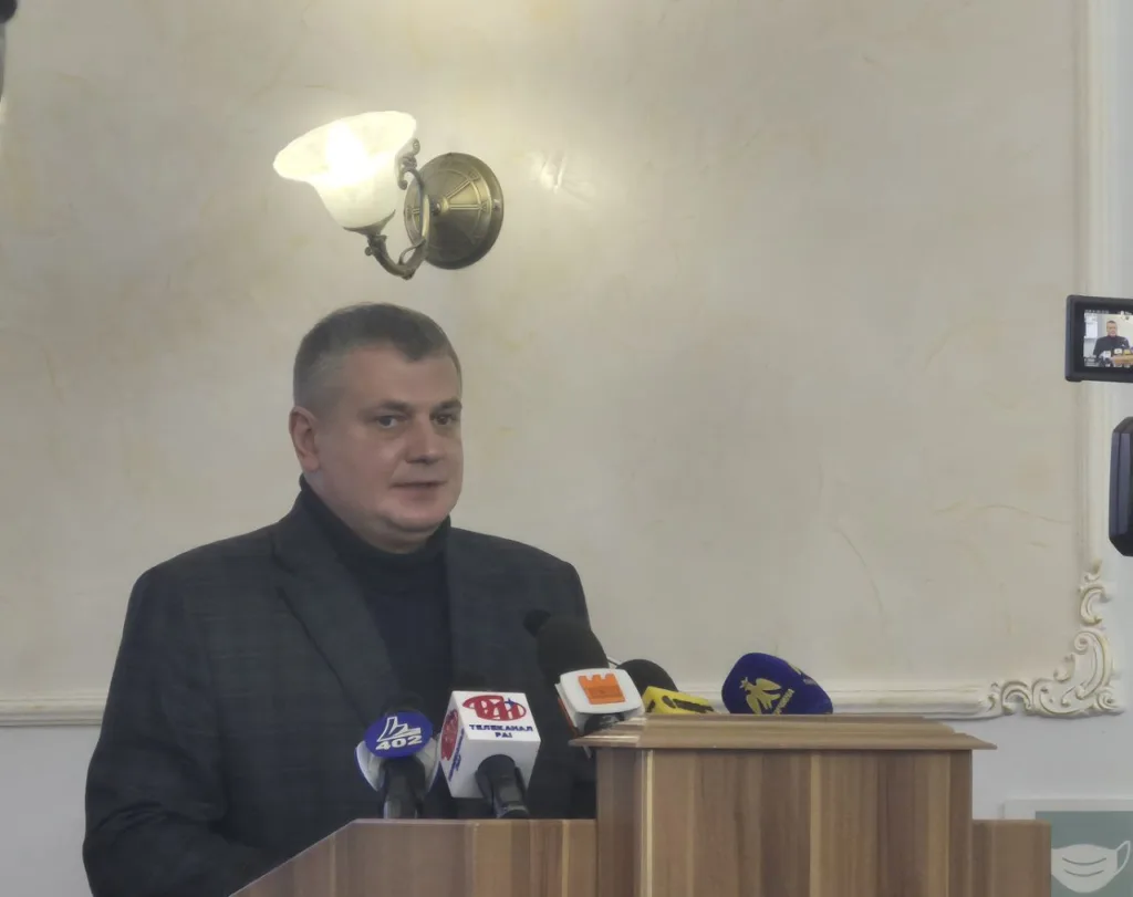 Чоловік виступає на пресконференції за трибуною