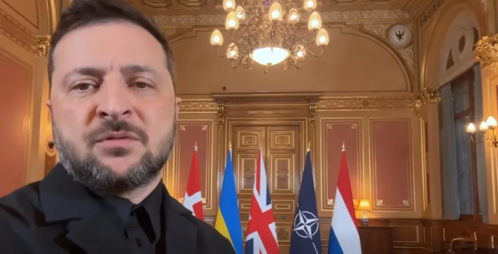 Чоловік у залі з прапорами України та НАТО