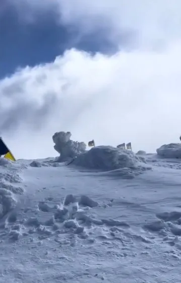 Снігова вершина з прапорами на вітрі