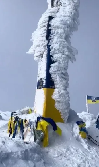 Засніжений стовп з українським прапором у горах