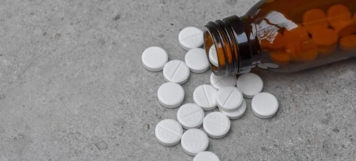 Білий пігулки поруч із коричневою пляшкою