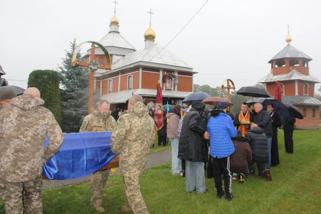 Похорон військового біля церкви під дощем