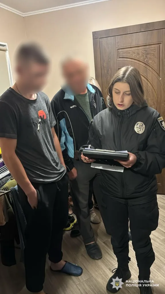 Поліцейська спілкується з двома чоловіками у кімнаті
