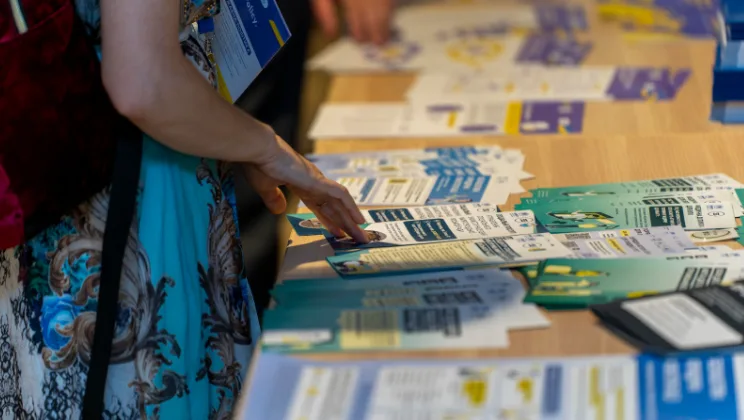 Жінка вибирає інформаційні буклети на столі