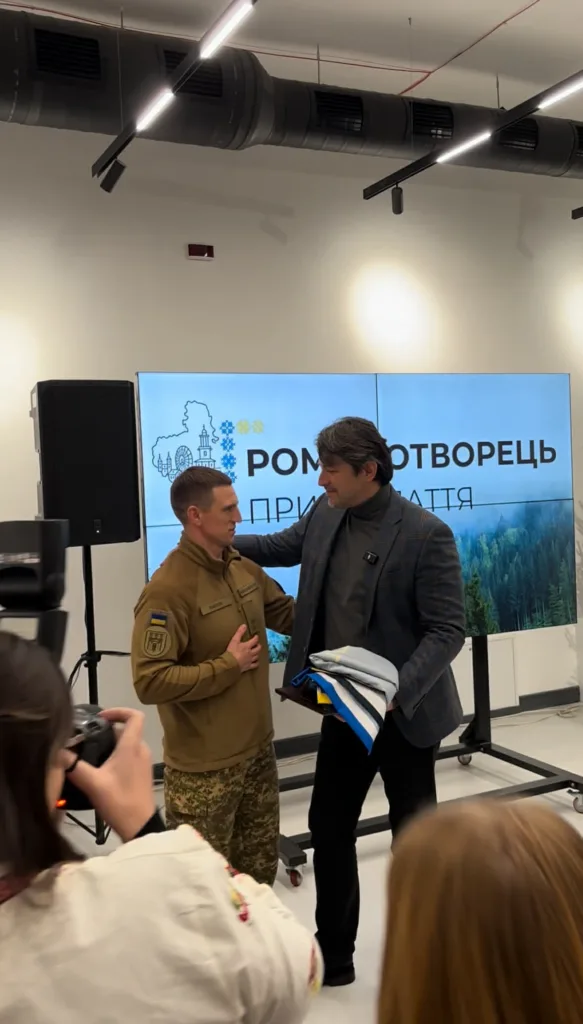 Військовий отримує подарунок на урочистому заході