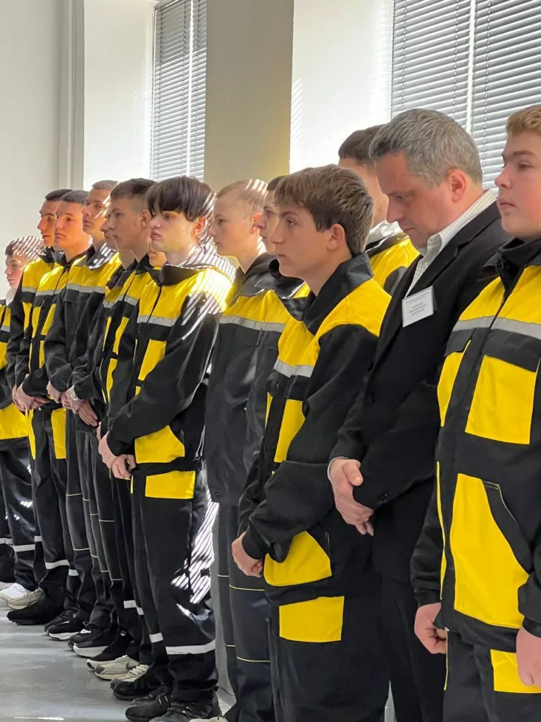 Група людей у жовто-чорній уніформі стоїть в ряд