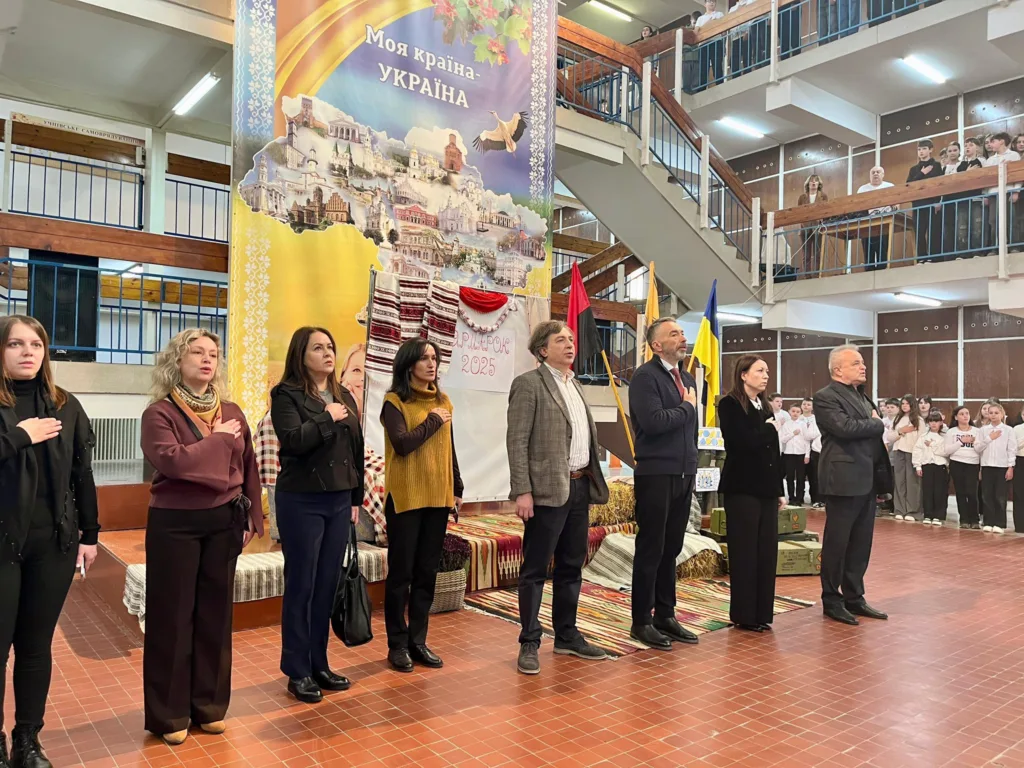 Люди співають гімн на шкільному заході в Україні