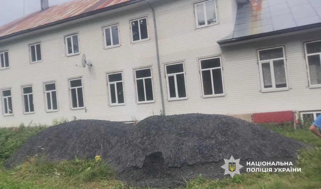 Купа вугілля біля двоповерхового будинку