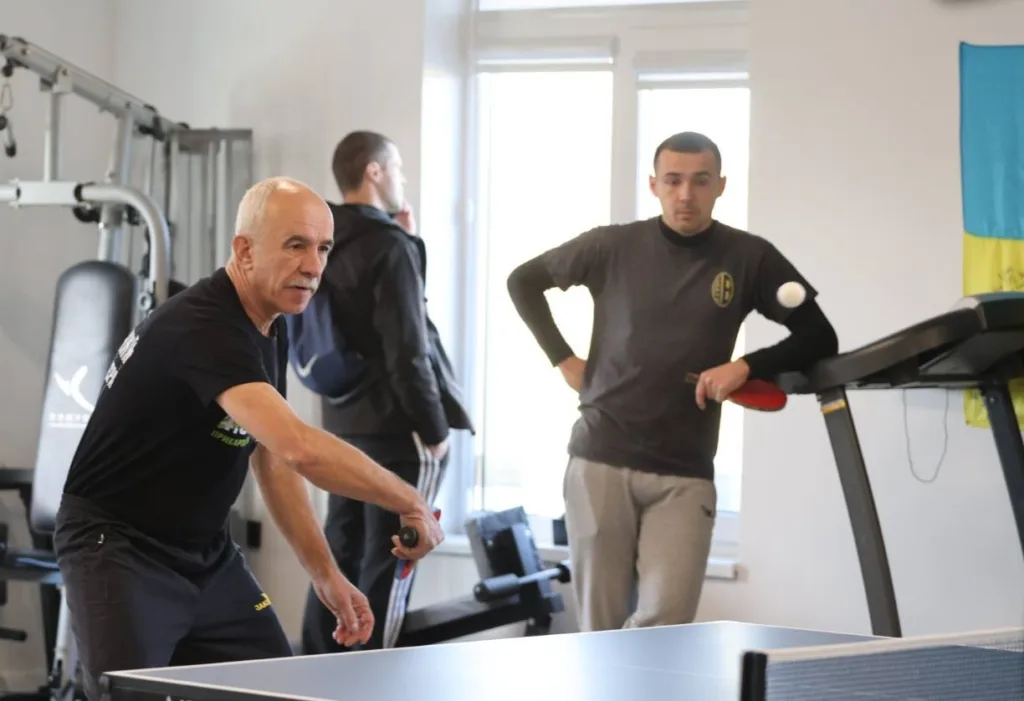 Чоловіки грають у настільний теніс у спортзалі