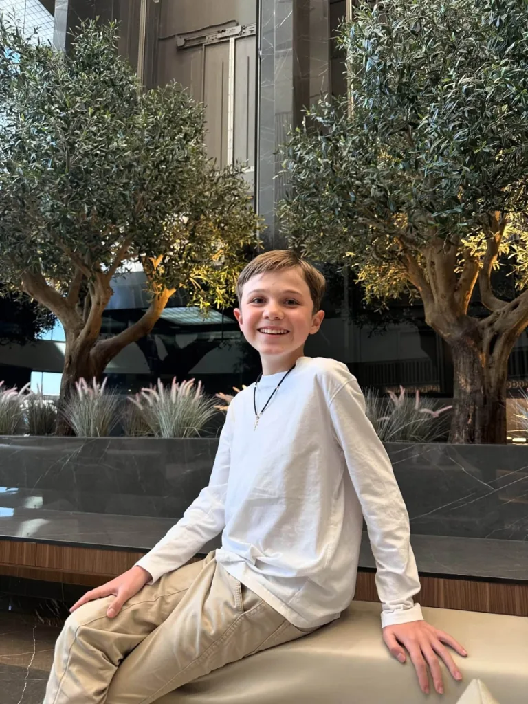 Хлопчик усміхається, сидячи в сучасному інтер’єрі