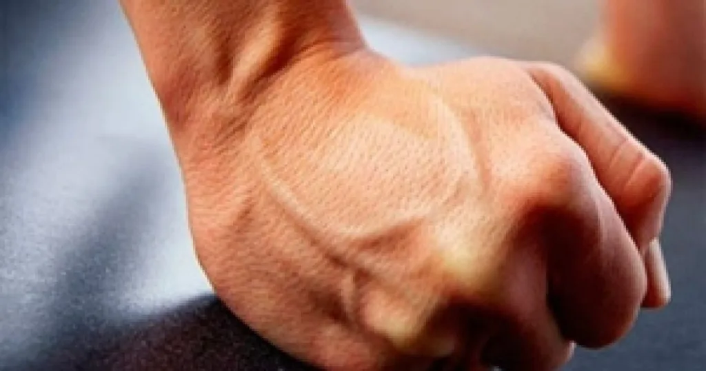 Стиснутий кулак на темній поверхні