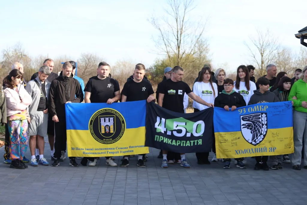 Люди тримають українські прапори під час заходу