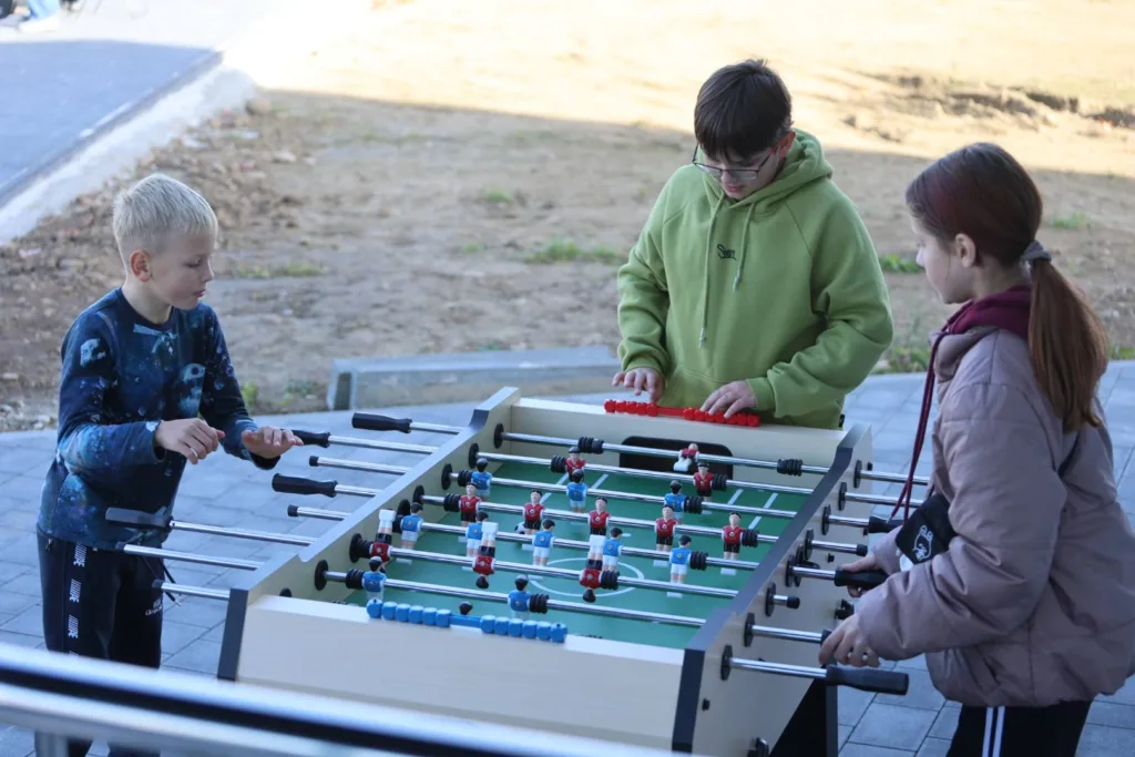 Діти грають у настільний футбол на вулиці