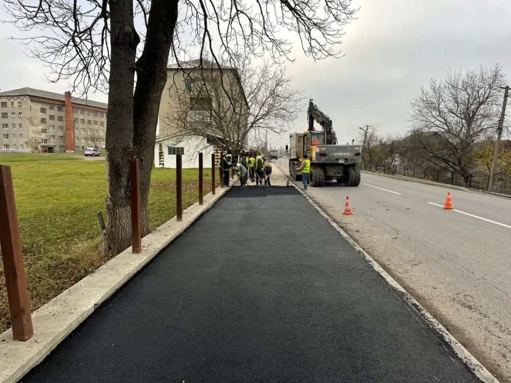 Робітники укладають новий асфальт на тротуарі