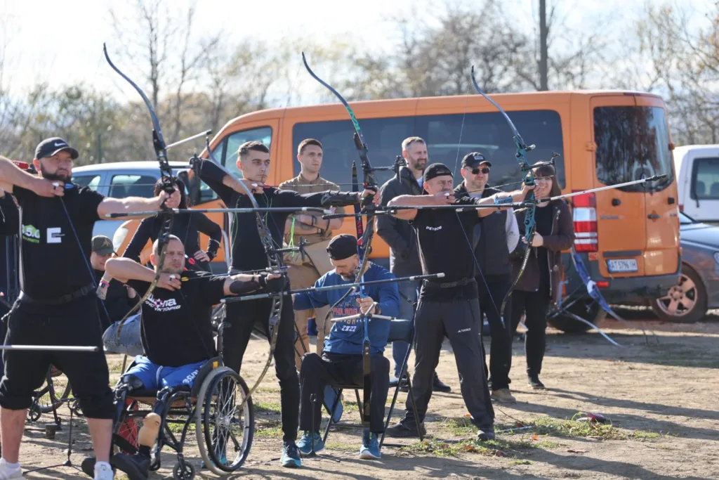 Люди стріляють з луків на відкритому полігоні