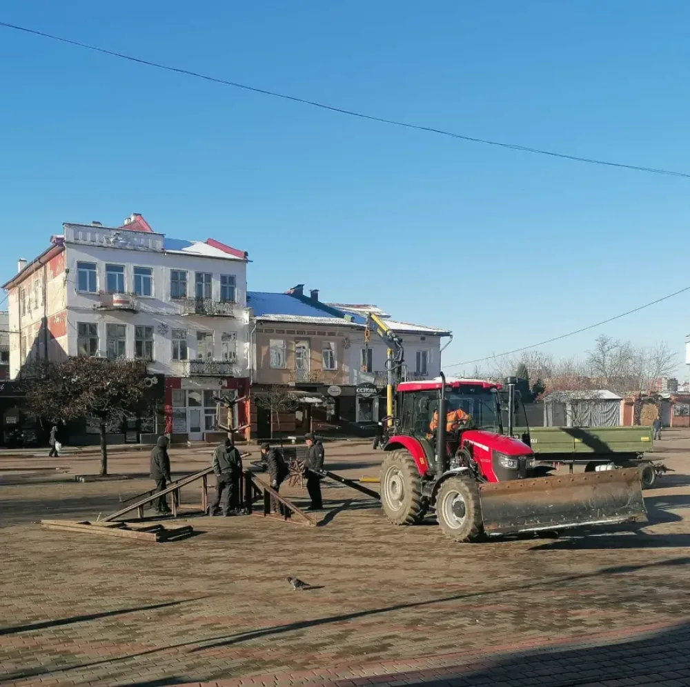 Трактор і робітники працюють на міській площі