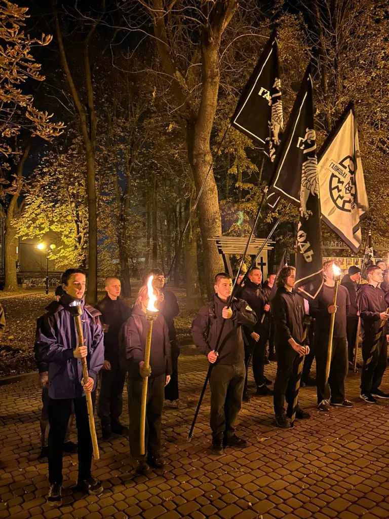 Люди з прапорами та смолоскипами в парку вночі
